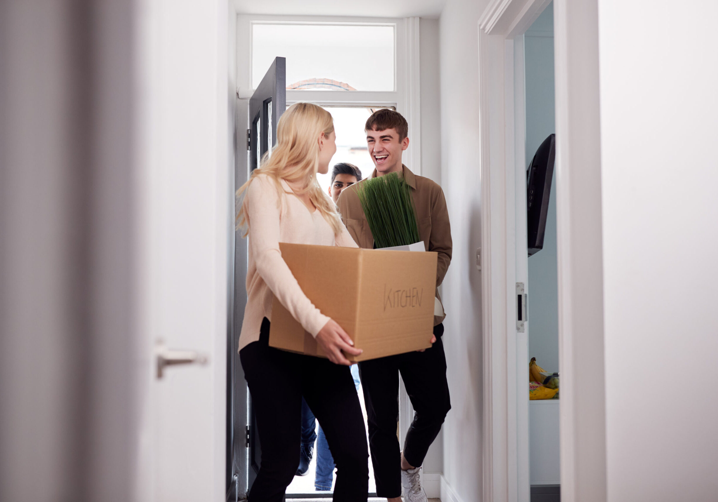 Group Of College Student Carrying Boxes Moving Into Accommodation Together